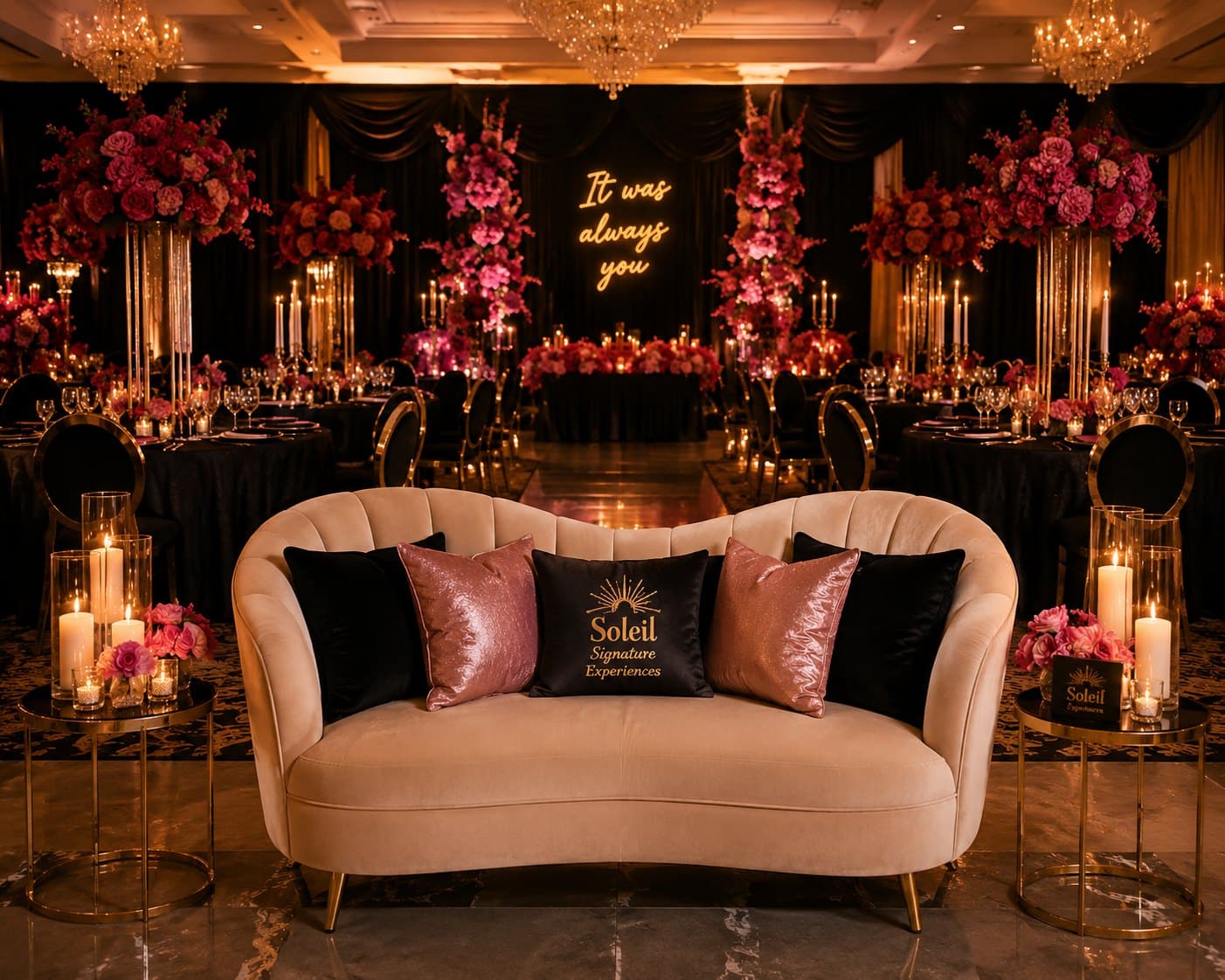 A candlelit reception lounge styled by Soleil Signature Experiences, with a velvet loveseat and an illuminated 'It was always you' sign.
