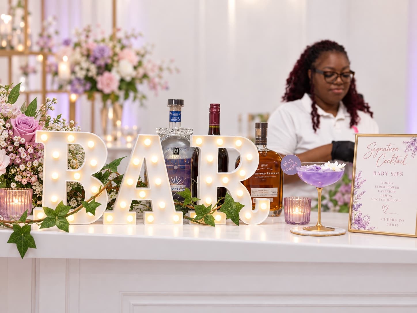 A styled bar setup with a marquee-letter 'BAR' sign and ivy garland, part of a Soleil-designed celebration.