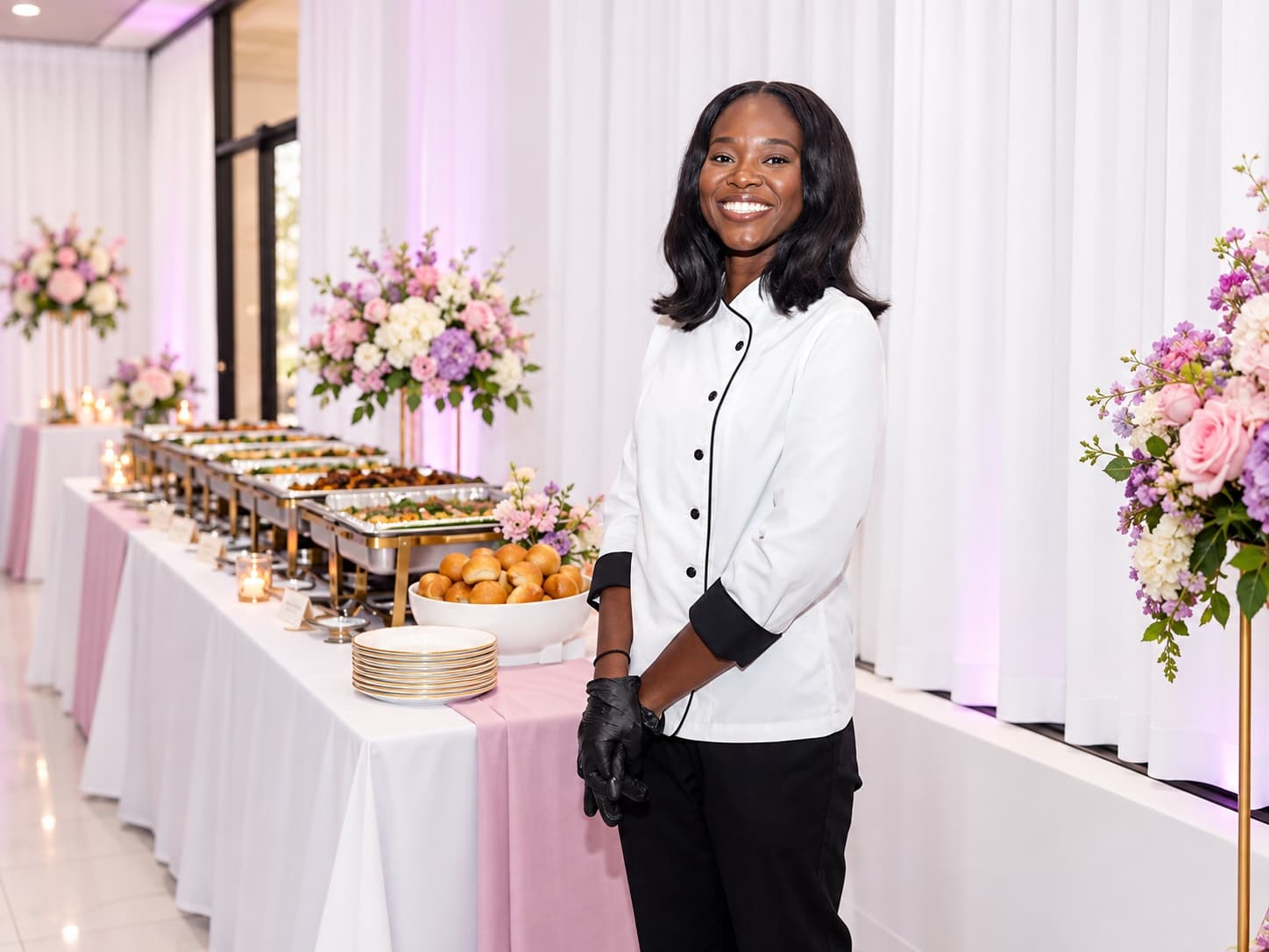 A caterer stands beside a styled buffet at a Soleil-designed celebration.